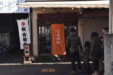 Aile küçük Japon restoranının girişinin önünde duruyor.