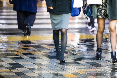 Yağmurlu bir günde sokakta yürüyen insanlar 