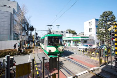 Modern şehir Japonya 'da gündüz tramvayı sokak sokak geziyor.
