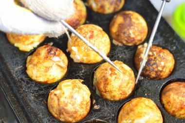 Takoyaki, top şeklinde Japon aperatifleri un bazlı hamurdan yapılmış ve özel kalıplı bir tavada pişirilmiş..