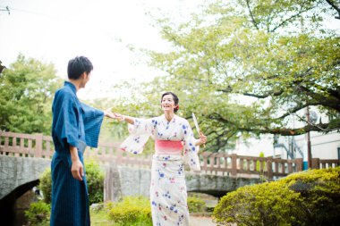 Genç Japon çift yaz parkında geleneksel kimono giyiyor.