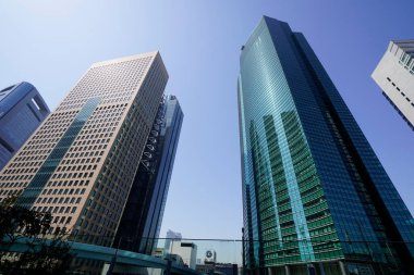 Modern şehir mimarisi, Tokyo, Japonya. Gökdelenler mavi gökyüzüne karşı güneşli bir günde 