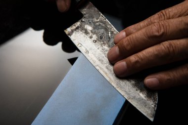 Bıçağı keskinleştiren kişinin ellerinde yakın çekim görüntüsü