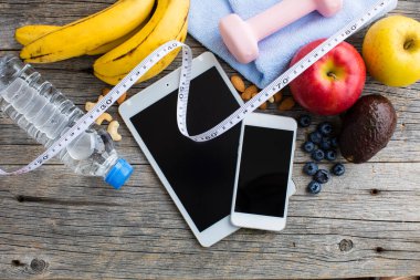 Dambıl, su şişesi, aletler, mezura ve ahşap zemin üzerindeki meyvelerin yakın plan görüntüsü. sağlıklı yaşam tarzı kavramı           