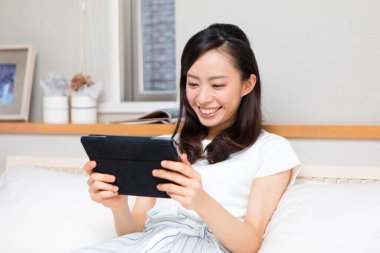 Evinde tableti olan güzel bir kız.