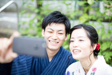 Genç Asyalı çift bahçede selfie çekiyor.