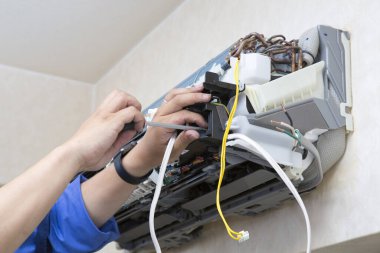 Adam havalandırma sistemini içeride tamir ediyor.