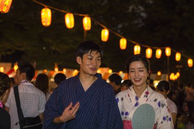 Akşam parkında geleneksel kimono giyen genç Japon çift.