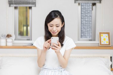 Genç ve güzel bir kadın telefonunu kullanıyor. 