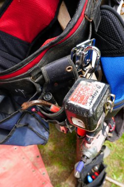 Kırmızı ve Siyah Kemerli Kerpeten, Karabina ve Uyarı Etiketli Çarpışma Sürücü Gücü Aracının Yakından Görünümü