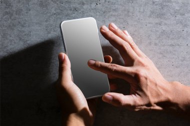 Erkek eli kapalı, elinde boş ekranla akıllı telefonu tutuyor. Reklam ve tanıtım tasarım konsepti