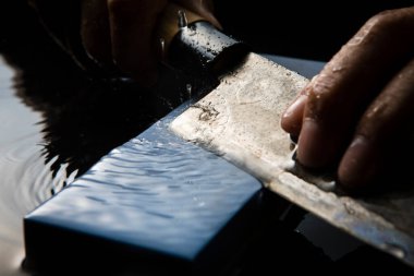 Bıçağı keskinleştiren kişinin ellerinde yakın çekim görüntüsü