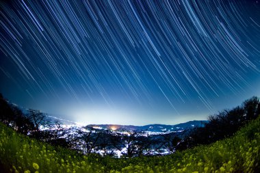 Kayan yıldızlar ve kırsal alan manzaralı gece gökyüzü