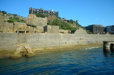 Yeşil şehir parkında eski taş duvar ve göl  