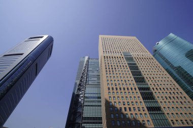 Modern şehir mimarisi, Tokyo, Japonya. Gökdelenler mavi gökyüzüne karşı güneşli bir günde 