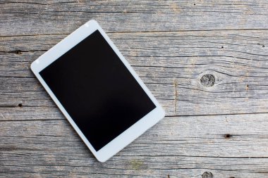 Ahşap arka planda modern dijital tablet. Kapat. 
