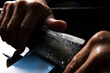 Bıçağı keskinleştiren kişinin ellerinde yakın çekim görüntüsü