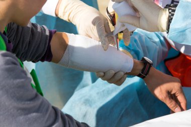 Yaralı adam için ilk yardım. Yakından bakın.