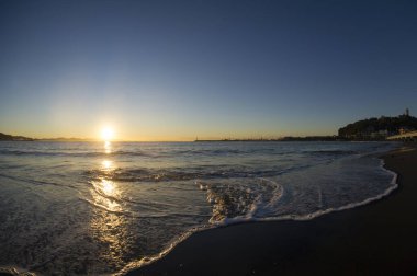 Sakin denizin üzerinde gün batımının güzel manzarası