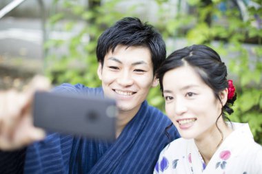 Genç Asyalı çift bahçede selfie çekiyor.