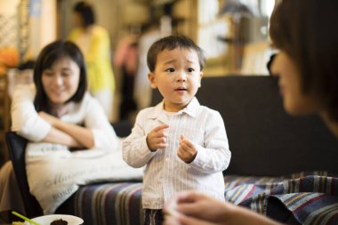 Genç çocuk yetişkinlerle konuşuyor.