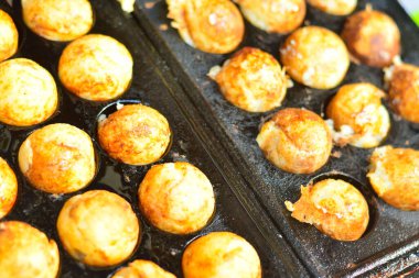 Takoyaki, top şeklinde Japon aperatifleri un bazlı hamurdan yapılmış ve özel kalıplı bir tavada pişirilmiş..