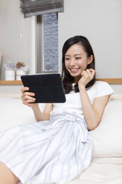 Evinde tableti olan güzel bir kız.