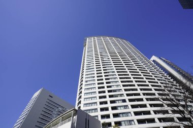 Modern şehir mimarisi, Tokyo, Japonya. Gökdelenler mavi gökyüzüne karşı güneşli bir günde 