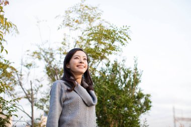 Genç Asyalı kadın yaz parkında mutlu. 