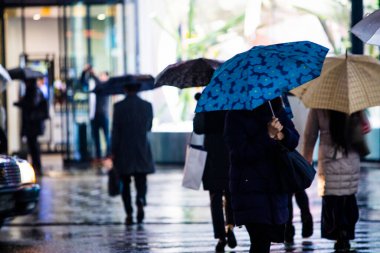 Yağmurlu bir akşamda sokakta yürüyen insanlar