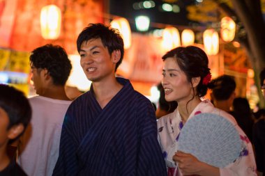 Akşam parkında geleneksel kimono giyen genç Japon çift.