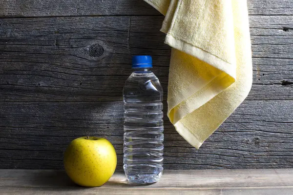Υγιεινό Τρόπο Ζωής Μπουκάλι Νερό Πετσέτα Και Μήλο Πάνω Ξύλινο — Φωτογραφία Αρχείου