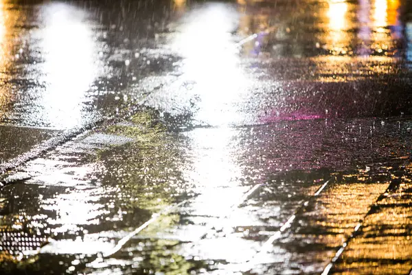 夜に雨が降る市街道の湿った道 — ストック写真