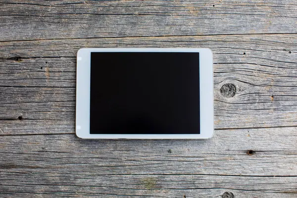 Ahşap arka planda modern dijital tablet. Kapat. 