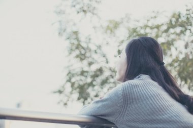 Asyalı güzel genç bir kadının portresi evinin balkonunda dinleniyor. 