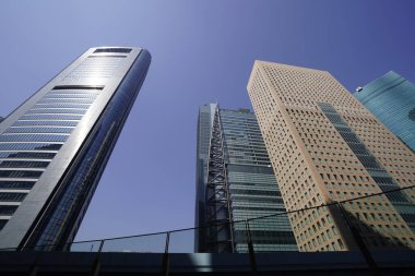 Modern şehir mimarisi, Tokyo, Japonya. Gökdelenler mavi gökyüzüne karşı güneşli bir günde 