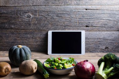 Tablet boş ekran ve masada sebzeler