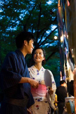 Akşam parkında geleneksel kimono giyen genç Japon çift.