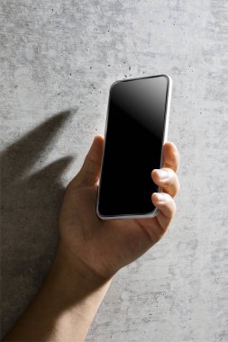 Erkek eli kapalı, elinde boş ekranlı akıllı telefon var. Reklam ve tanıtım tasarım konsepti