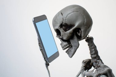 Cep telefonu tutan insan iskeleti. Cadılar Bayramı konsepti
