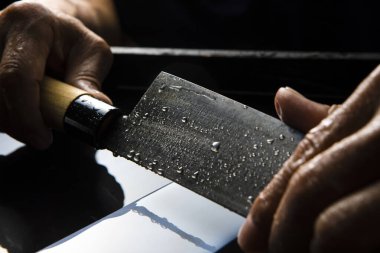 Bıçağı keskinleştiren kişinin ellerinde yakın çekim görüntüsü