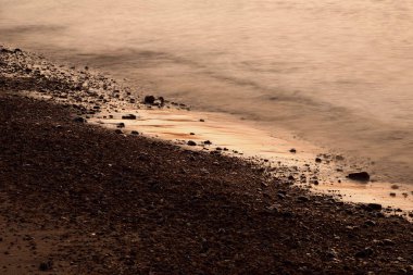 Sahilde güzel deniz dalgaları, gün batımı ışığı
