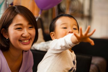 Gülümseyen kadın ve çocuk balona uzanıyor