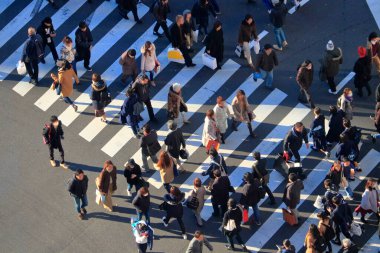 Karşıdan karşıya geçen bir sürü insan var.