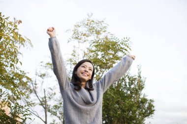 Genç Asyalı kadın yaz parkında mutlu. 