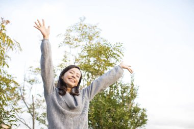 Genç Asyalı kadın yaz parkında mutlu. 