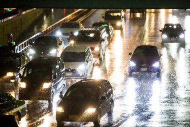 cars and night city lights on wet road clipart