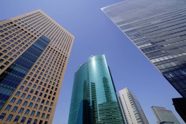 Modern şehir mimarisi, Tokyo, Japonya. Gökdelenler mavi gökyüzüne karşı güneşli bir günde 