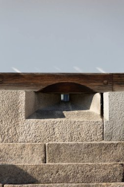 Küçük bir açıklık ve tahta kiriş içeren taş yapı.