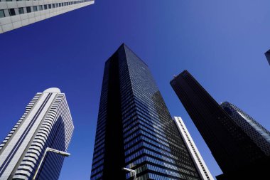 Modern şehir mimarisi, Tokyo, Japonya. Gökdelenler mavi gökyüzüne karşı güneşli bir günde 